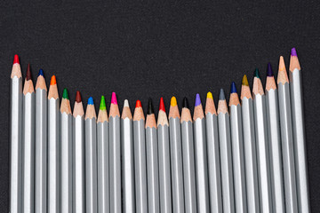 gray wooden pencils with colored rods on a black background