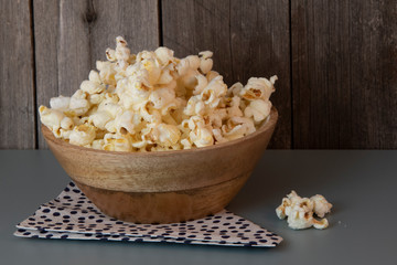 Popcorn in wooden bowl, simple, wooden background