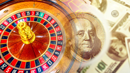 Games for money. Dollars next to a roulette wheel. Concept - losing money in a casino. Concept - a trip to cauldron. Relaxation. Winning money in gambling. Top view table with tape measure. Franklin