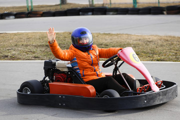 girl is driving Go-kart car with speed in a playground racing track.