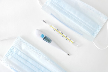 Two thermometers between face masks