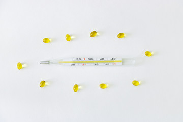 Glass thermometer surrounded by medications