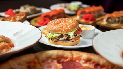 hamburgers in a cafe in a composition with pizza, salad, potatoes