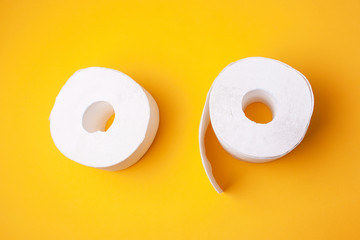 Two rolls of toilet paper on a yellow background. Flat style