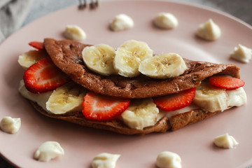 Delicious banana oatmeal pancake on a plate. Oatmeal pancake with cream cheese, banana and strawberries