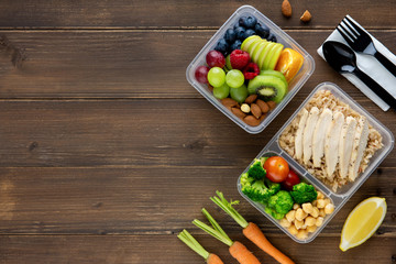 Top view of wholesome nutrient rich food set in take away boxes on wood table background with copy space