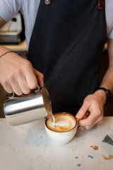 Fototapeta na wymiar bartender is preparing a cappuccino in a cafe