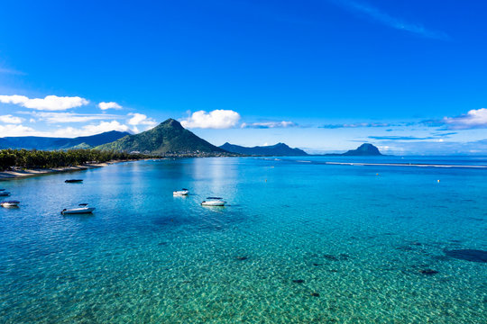 The beach at Flic en Flac with luxury hotels and palm trees, behind the mountain Tourelle du Tamarin, Mauritius, Africa