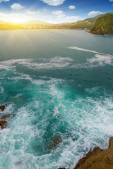 Ocean wave crashing on rock in the bay