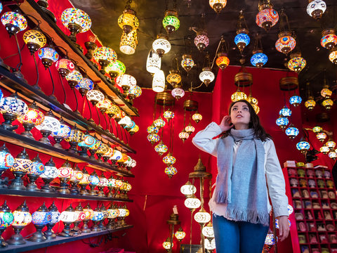 Cute girl looks traditional lamps at store