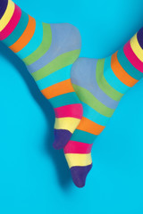 Man with rainbow socks on color background. 