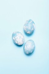 Blue speckled Easter egg on blue background