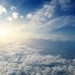 Fototapeta na wymiar Sunrise above clouds from airplane