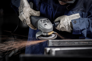 Close up on a man hold an angle grinder with sparks