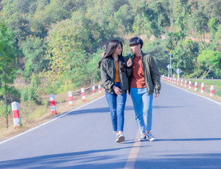 Young female couple holding hands standing on their way together.
