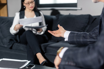 cropped view of businessman talking with asian businesswoman