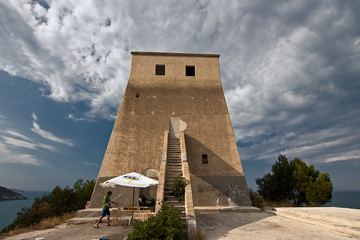 A seller of local products with his counter near a medieval watchtower in the Gargano in Italy.