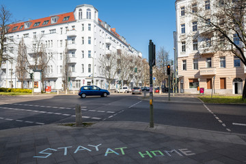 Stay At Home - Schriftzug auf dem Gehweg des Schievelbeiner Strasse in Berlin-Prenzlauer Berg