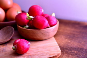 Radish in a wooden bowl and white cloth
