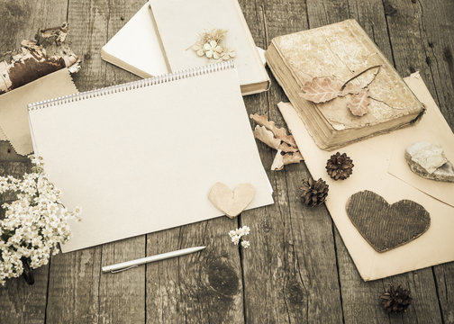 Exercise book mock-up and vintage objects on rustic wooden table. Vintage autumn mockup background. Mock up. Toned image in retro style.
