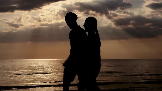 Happy asian couple walking with romantic and holding hand on the beach in summer together, man and woman stroll and dating in vacation for honeymoon with silhouette, holiday and travel trip concept.