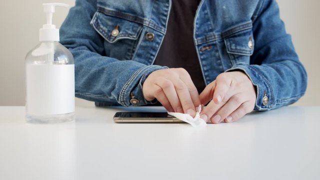 male clean mobile phone with sanitizing wipe 