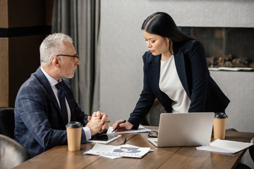 businessman talking with asian businesswoman during business meeting