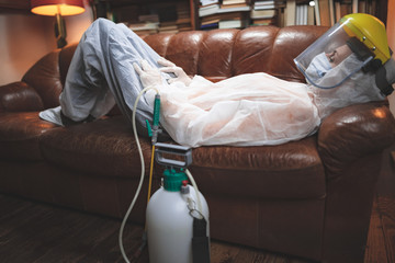 Person with protective antiviral mask, chemical decontamination sprayer bottle in home isolation.