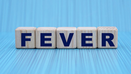 concept word FEVER on cubes on a striped blue background