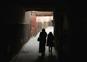 Siluetas de personas caminando por un callejón en Marrakech