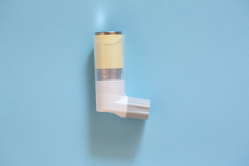 Inhaler on a blue background. The cure for asthma.