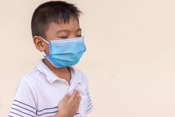 5-6 years old of Asian child boy wearing a protection mask for prevent Covid-19 ,Corona virus and PM 2.5 air pollution. He have an illness, Sore throat and flu. On white background. Healthy care.