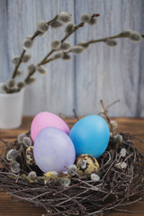 Colorful Easter eggs in a nest on a wooden table