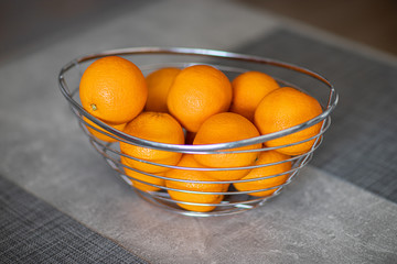 Pomarańcze w koszyku na stole.