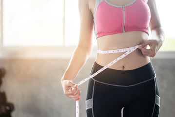 Young woman using waist strap at the gym