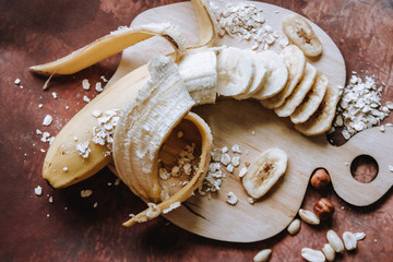 Banana and banana chips on the chopping dock and brown background