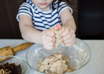 Easter concept. happy cute child girl is are preparing the Easter cakes, bake cookies in the kitchen. Portrait of happy funny kid in the Easter