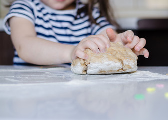 Easter concept. happy cute child girl is are preparing the Easter cakes, bake cookies in the kitchen. Portrait of happy funny kid in the Easter