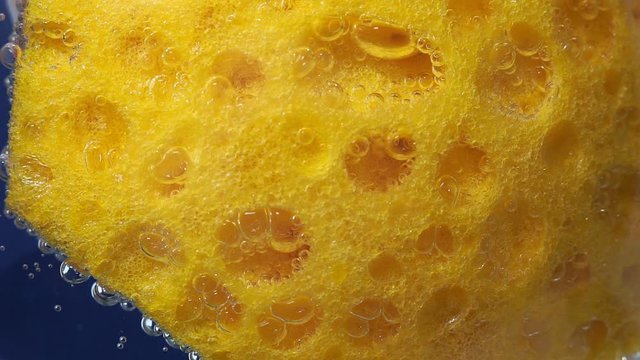 dishwashing sponge texture background. Surface of yellow sponge for washing dishes. close-up underwater
