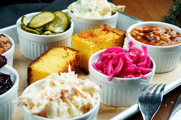 A set of different snacks for meat - pickled cucumbers, cole slow salad, chili con carne, boiled beetroot