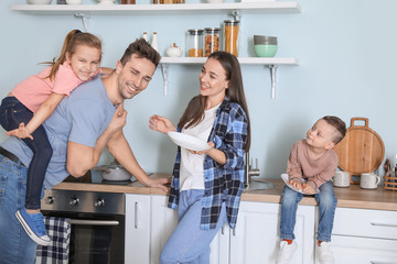 Young family washing dishes in kitchen