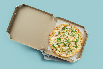 Conceptual poster for food and pizza delivery. Meat pizza in a cardboard box for delivery on a blue...