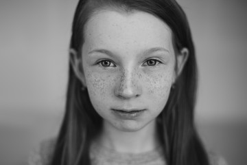 Fototapeta premium Close up portrait of young expressive emotional ginger girl with freckles on her face looking at camera. Natural beauty, red headed,freckled people concept