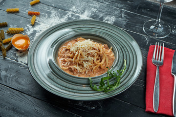 Appetizing homemade pasta bolognese with red sauce and minced meat, parmesan in a blue plate. Close up, top view. Italian spaghetti, photo for the recipe