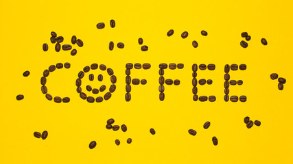 Coffee with smiley lettering ritten with brown coffee beans on yellow background