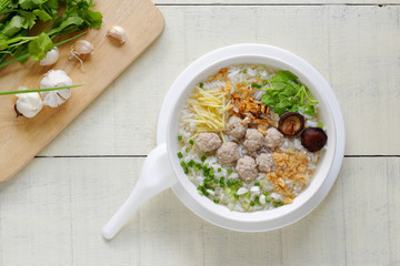 Thai Rice Soup With pork with sliced spring onion,mushroom ,ginger and deep fried garlic (Khao Tom moo sap).popular breakfast in Thailand