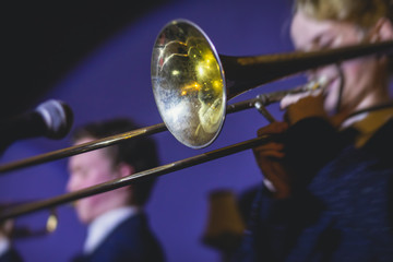 Concert view of a trombone player trombonist with musical jazz band performing in the background