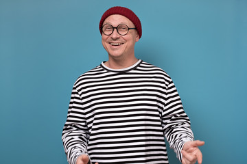 Naklejka premium Young attractive caucasian man in red hat and striped clothes laughing