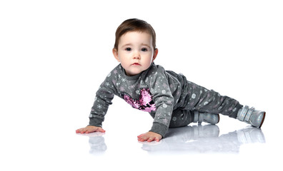 Toddler in gray suit with snowflakes print and boots. She is sitting on floor isolated on white studio background. Close up