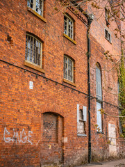 Old dilapidated factory building. Brick construction, broken glass. Abandoned, empty factory.